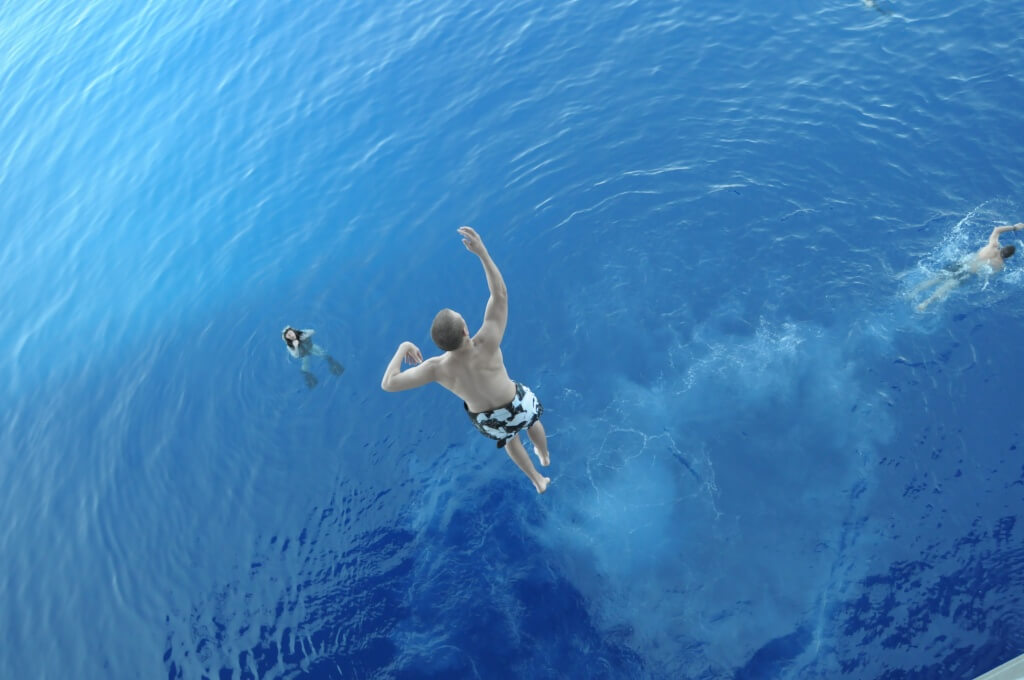 090711-N-8154G-321 U.S. 5TH FLEET AREA OF RESPONSIBILITY (July 11, 2009) A Sailor assigned to the amphibious assault ship USS Bataan (LHD 5) jumps from a platform in the ship’s hangar bay into the Gulf of Aqaba during a swim call. Bataan is serving as the flagship of the Bataan Amphibious Ready Group (ARG), supporting maritime security operations in the U.S. 5th Fleet area of responsibility. (U.S. Navy photo by Mass Communication Specialist 2nd Class Jeremy L. Grisham/Released)